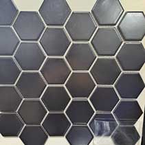 A close up of a black hexagon tile on a wall.