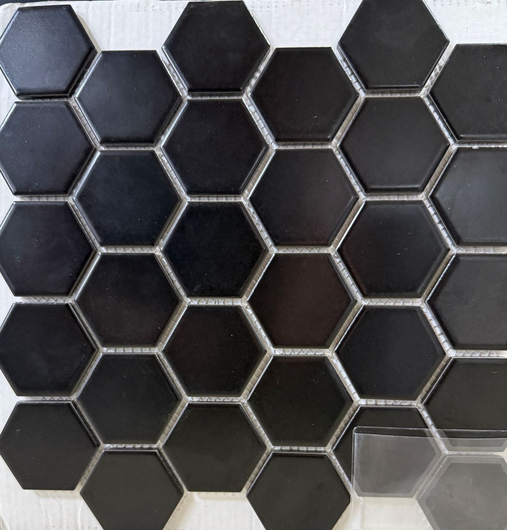 A close up of black hexagon tiles on a white surface