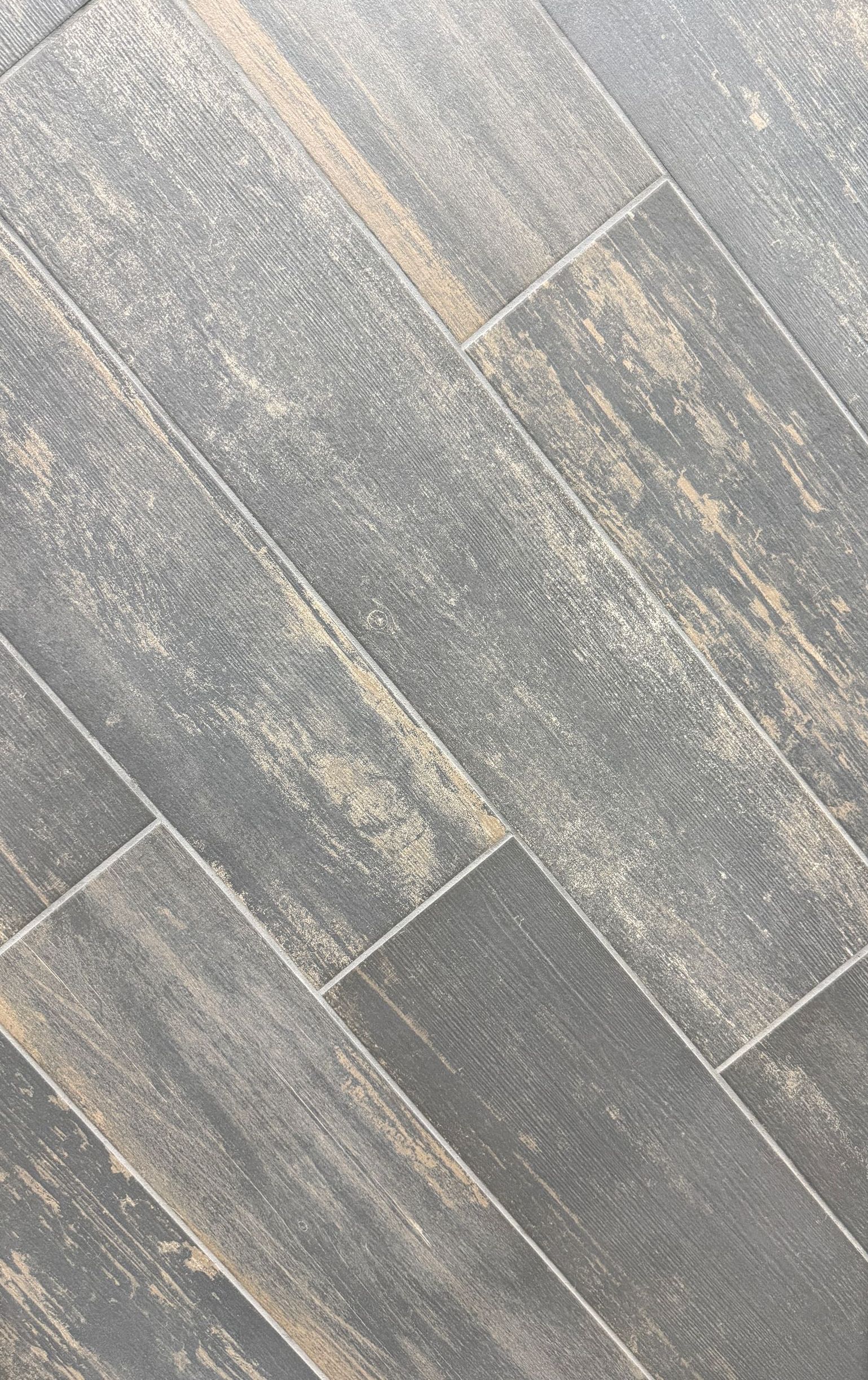 A close up of a tile that looks like wood.