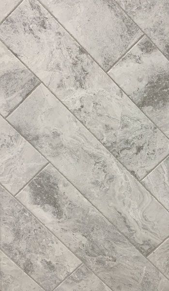 A close up of a gray tile floor with a diagonal pattern.