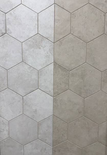 A close up of a gray tile floor that looks like wood.