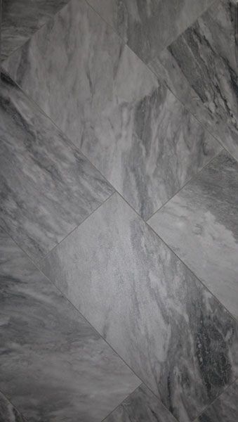 A close up of a gray tile floor with a marble texture.