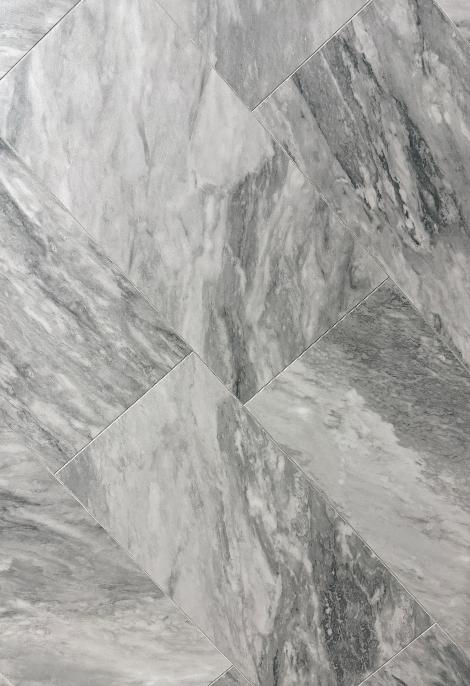 A close up of a gray tile floor with a marble texture.