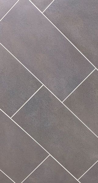 A close up of a gray tile floor with white grout.