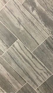 A close up of a gray tile floor with a diagonal pattern.