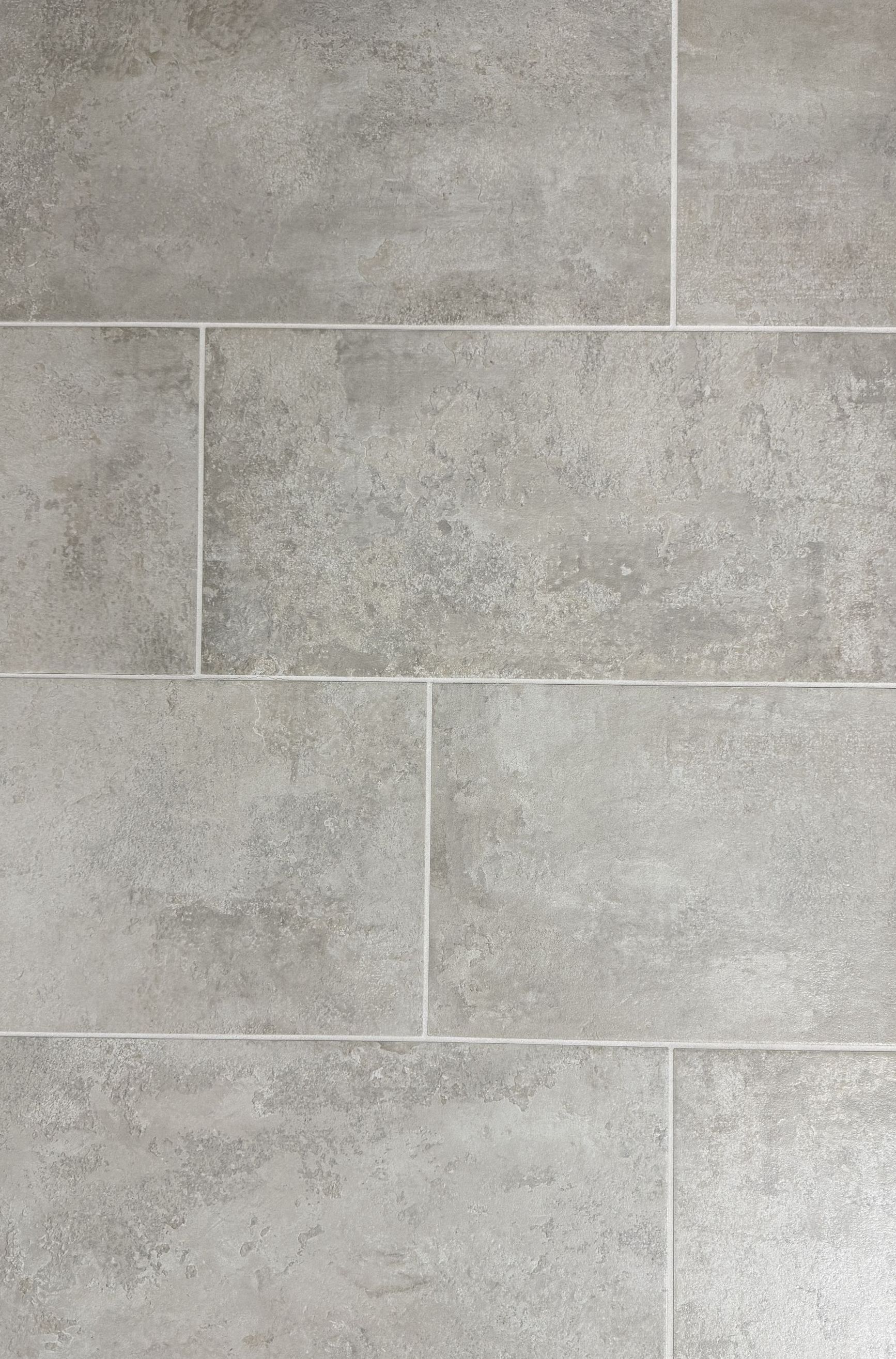 A close up of a gray tile floor that looks like wood.