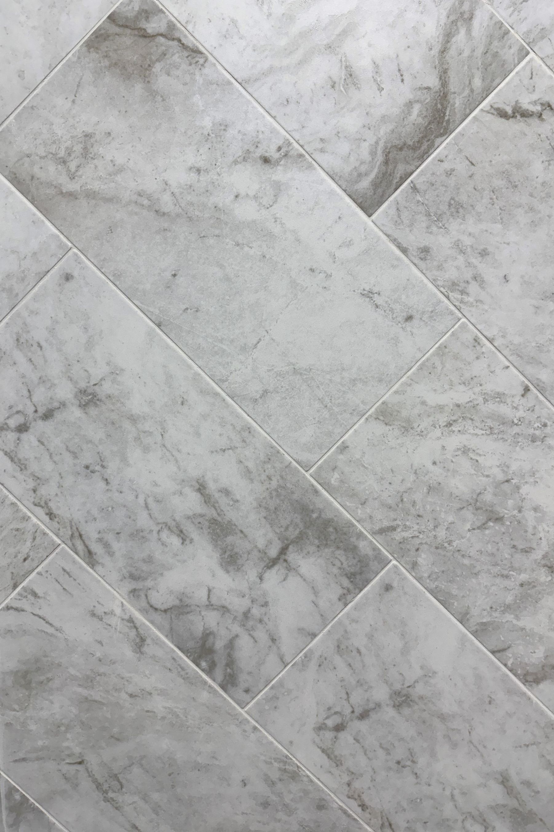 A close up of a white marble tile floor.