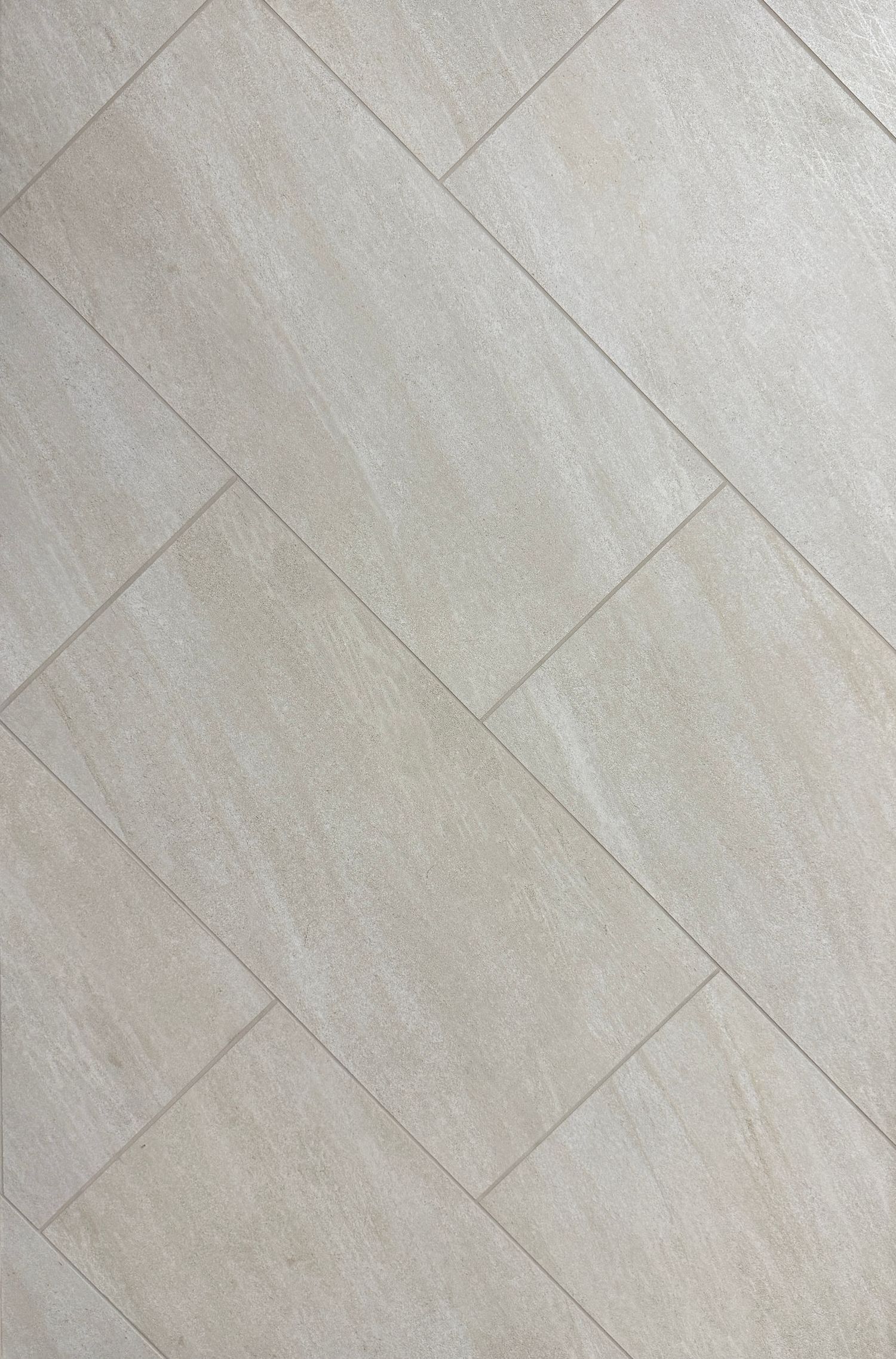 A close up of a tiled floor with a diagonal pattern.