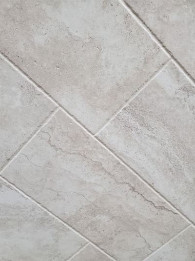 A close up of a tile floor with a diagonal pattern.