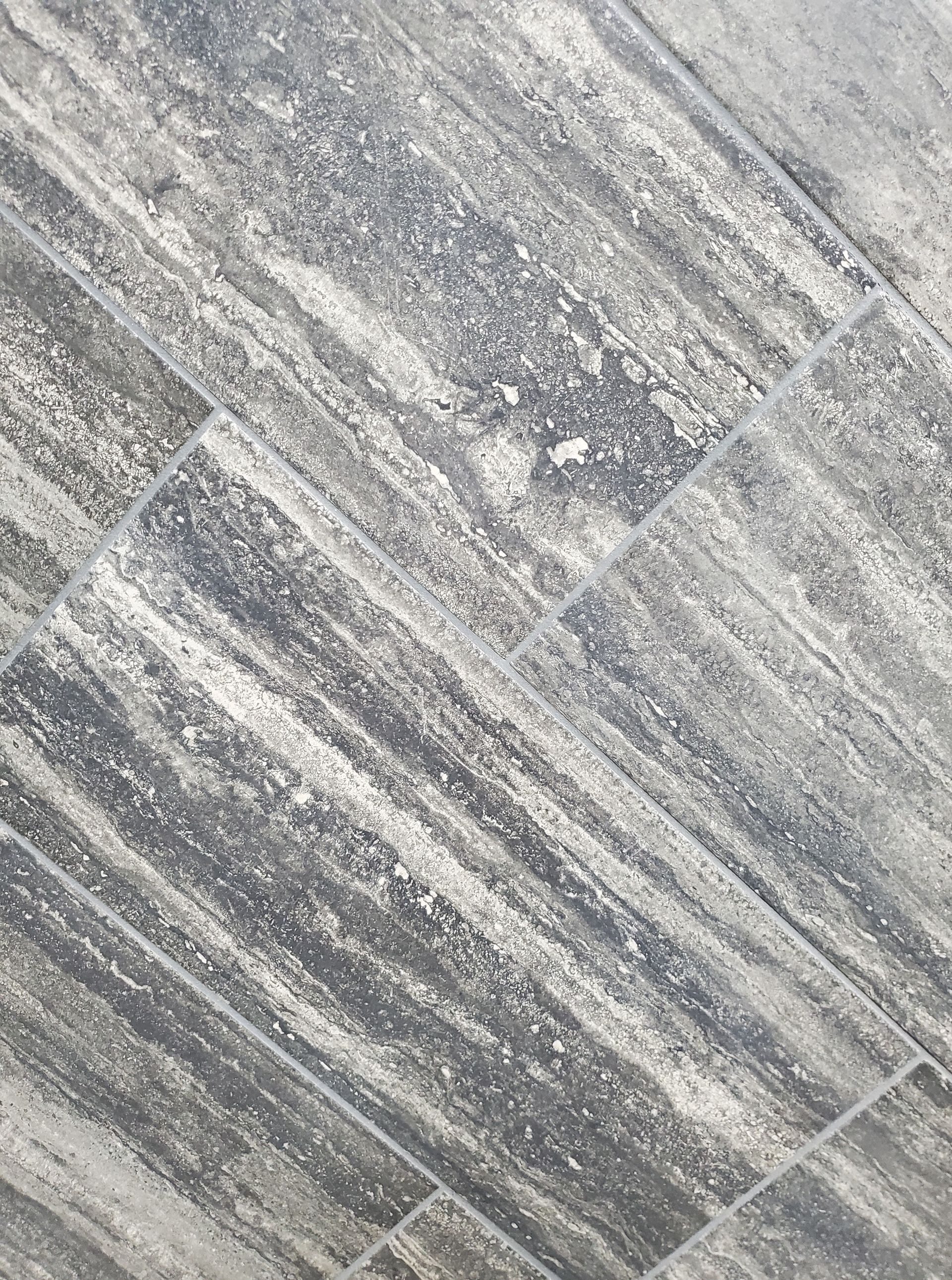 A close up of a gray tile floor.