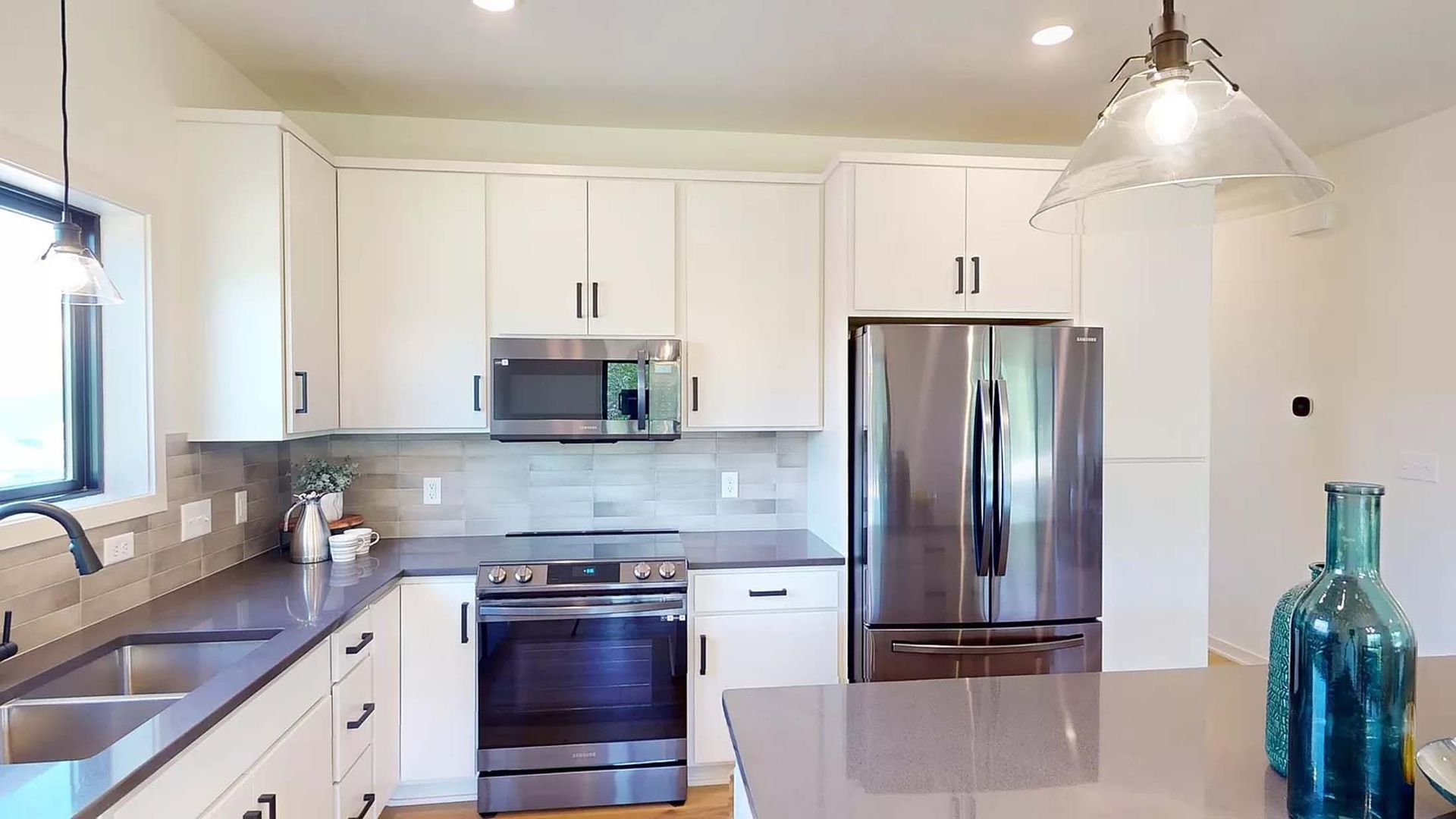 A kitchen with white cabinets and stainless steel appliances.