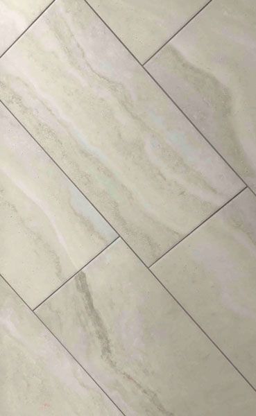 A close up of a white tile floor.