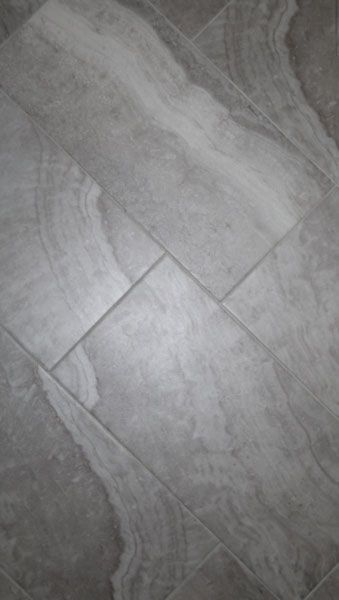 A close up of a gray tile floor in a bathroom.