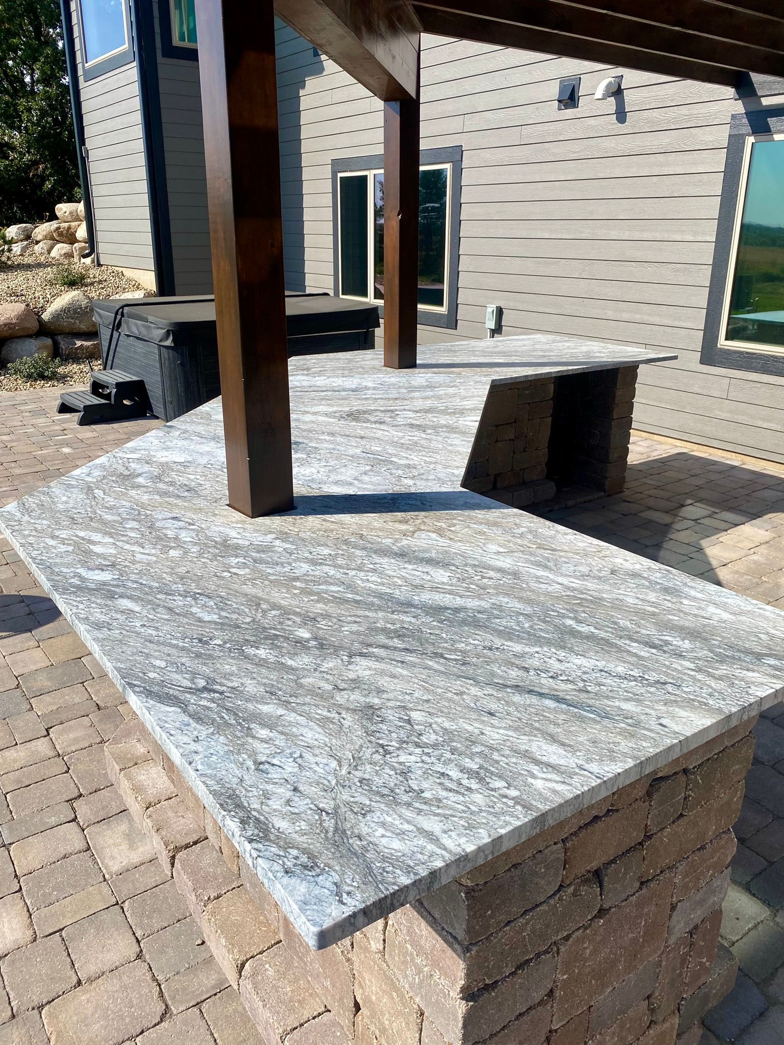 A granite counter top is sitting on top of a brick patio.