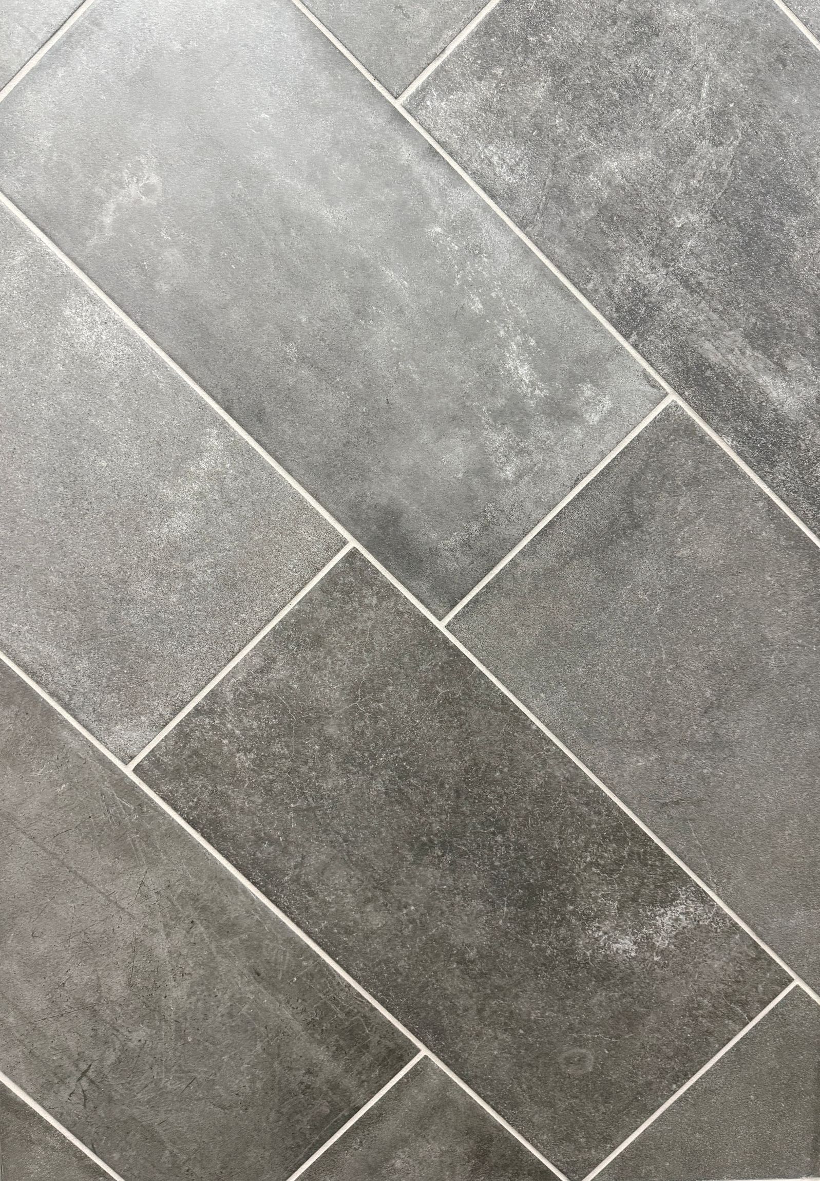 A close up of a gray tile floor that looks like wood.