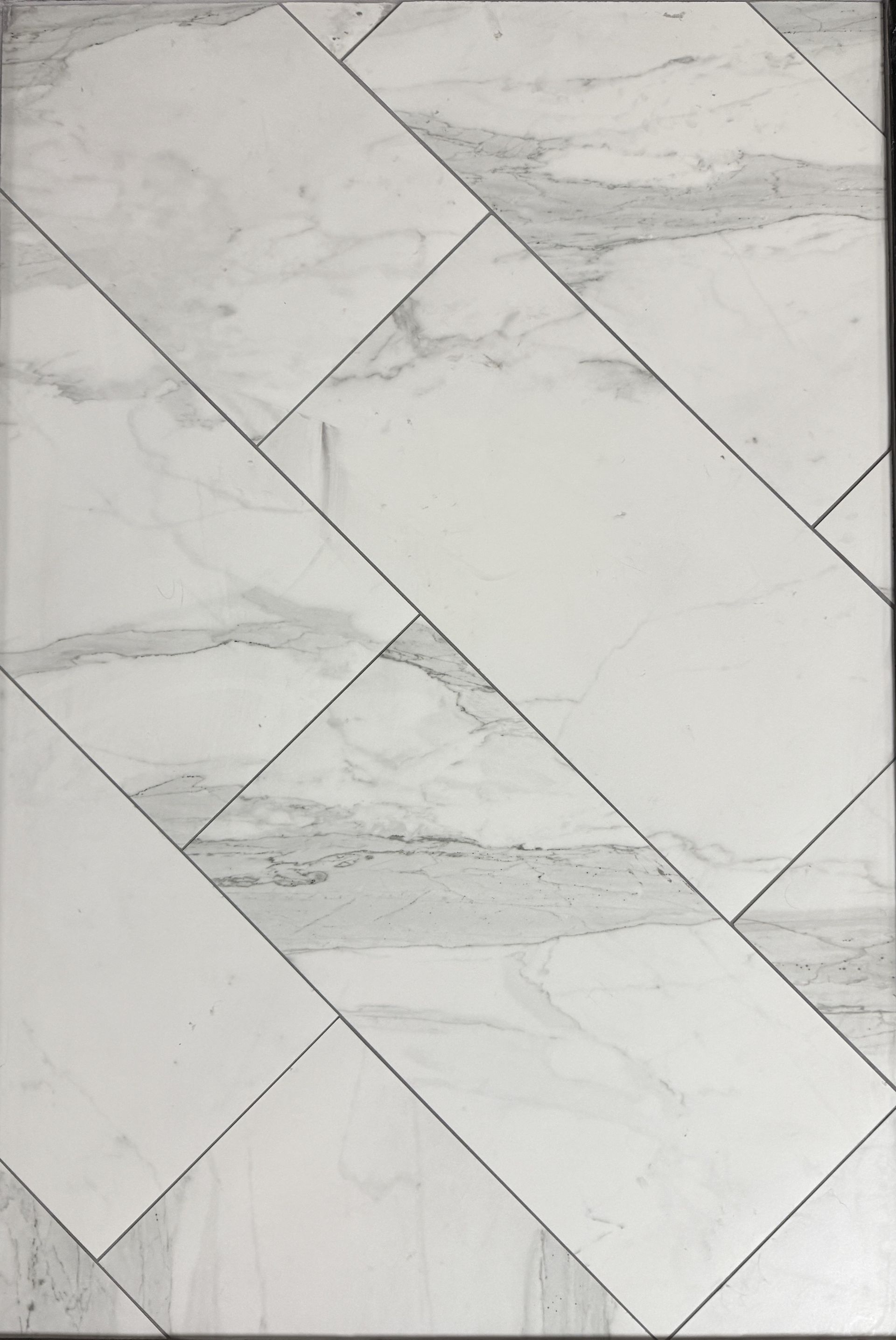 A close up of a gray tile floor that looks like wood.