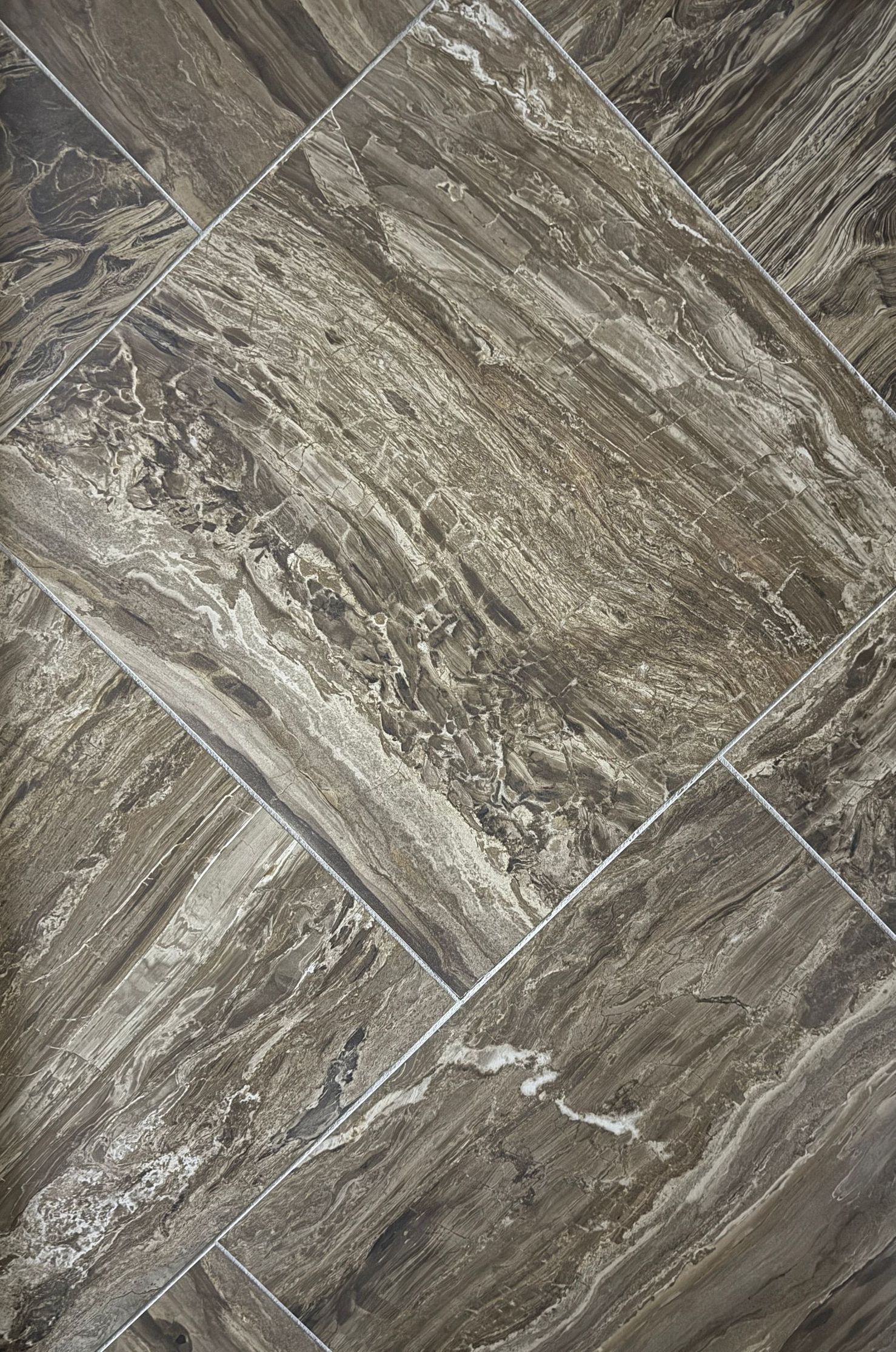 A close up of a tile floor with a marble texture.