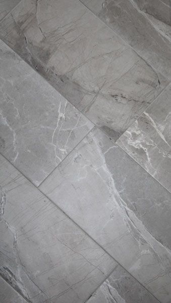 A close up of a gray tile floor with a marble texture.