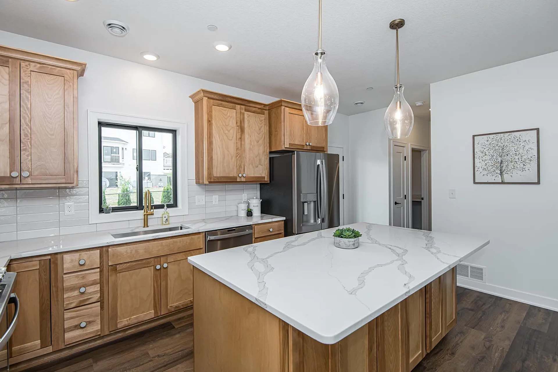 A kitchen with wooden cabinets , white counter tops , and a large island.