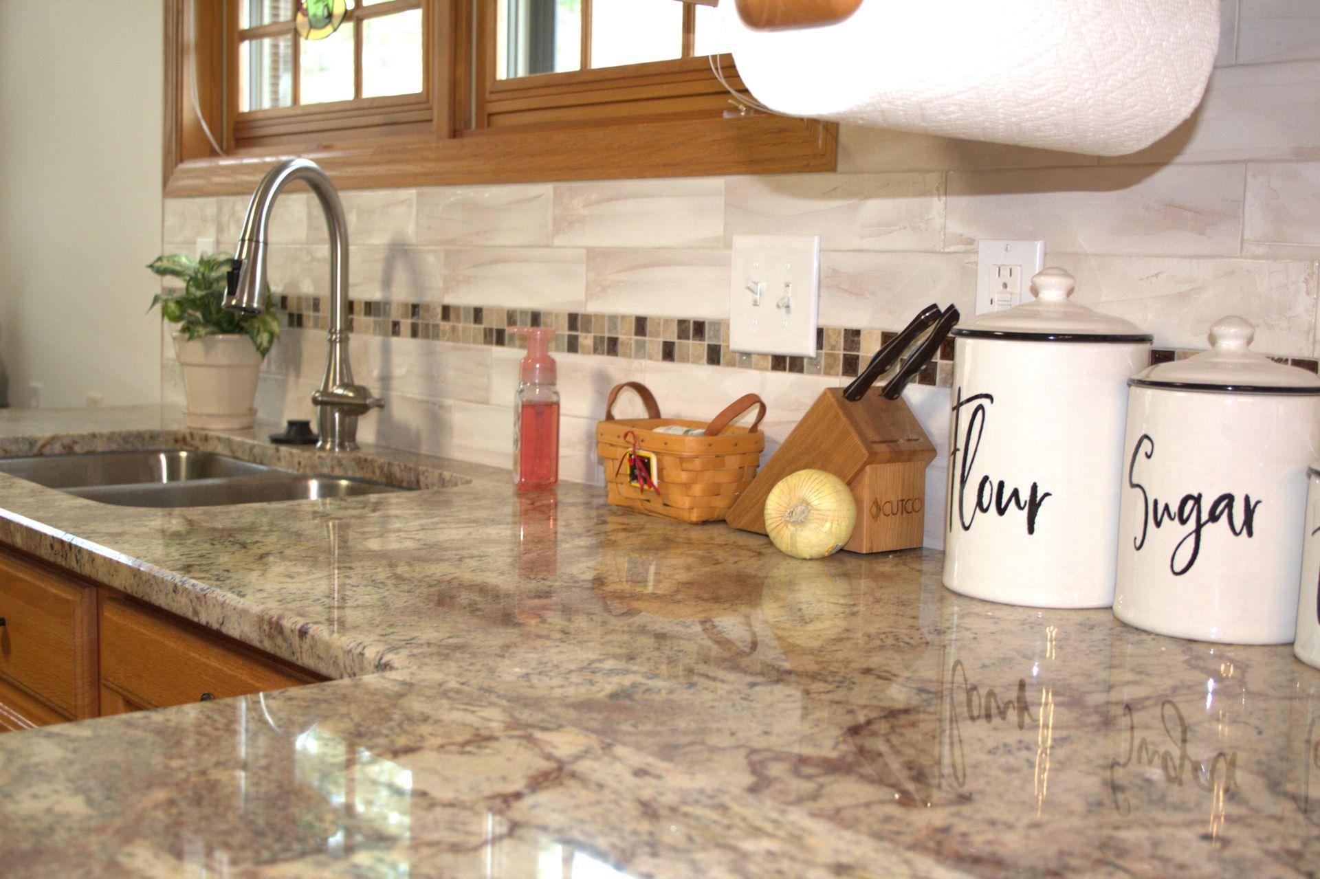 Kitchen countertop with a sink, faucet, and containers labeled 
