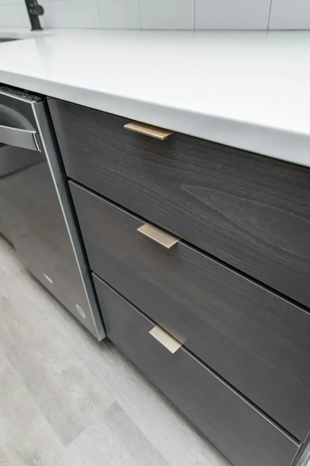A close up of a kitchen counter with drawers and a dishwasher