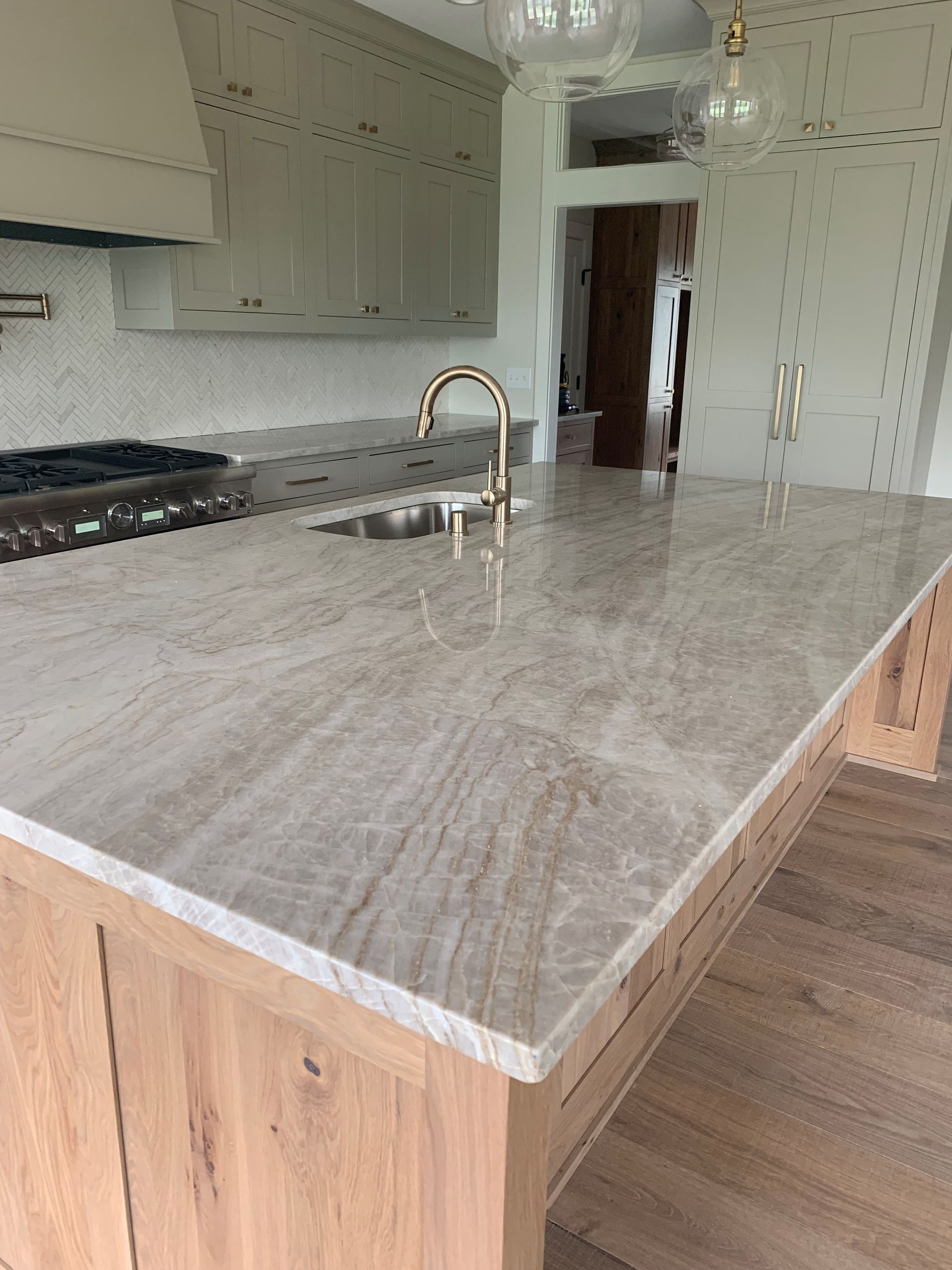 A kitchen with a large island and a sink.