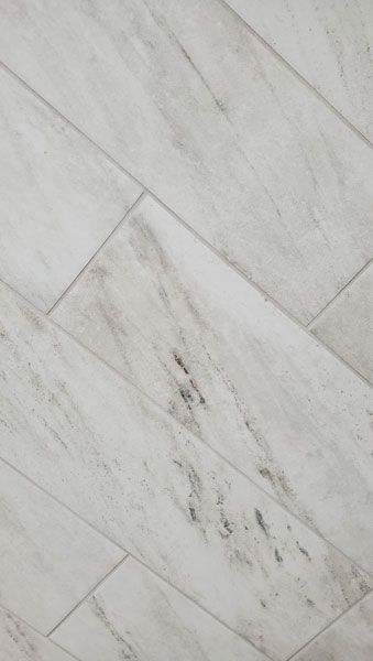 A close up of a white tile floor.