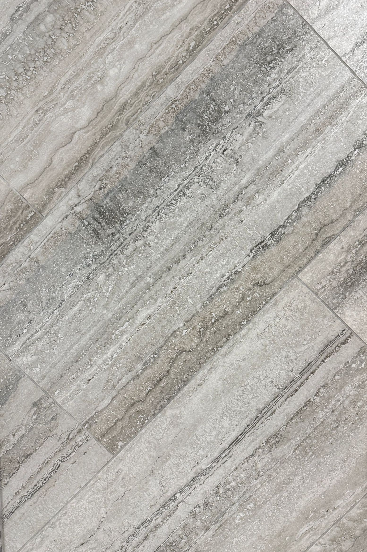 A close up of a tile floor that looks like wood.