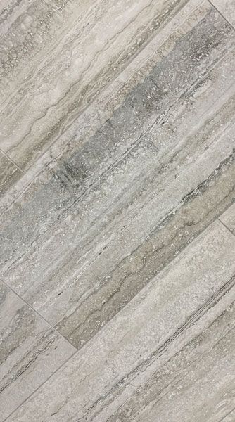 A close up of a gray tile floor that looks like wood.