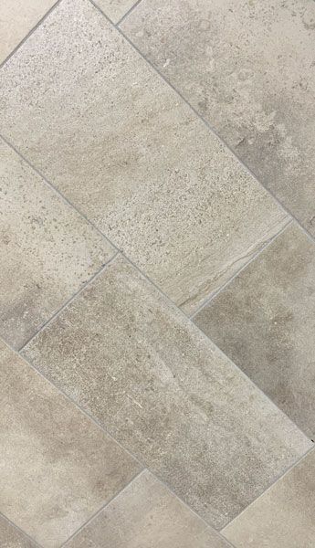 A close up of a tile floor with a diagonal pattern.