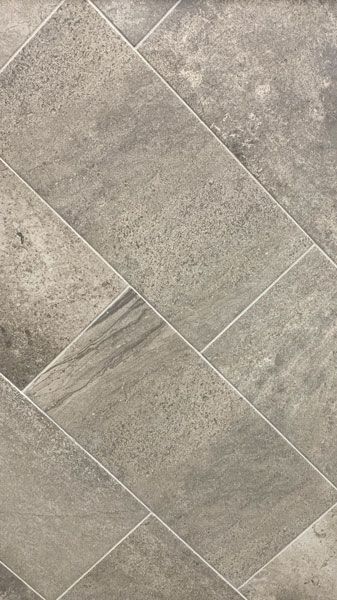 A close up of a gray tile floor with a diagonal pattern.