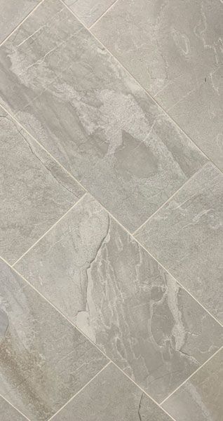 A close up of a tile floor with a marble texture.