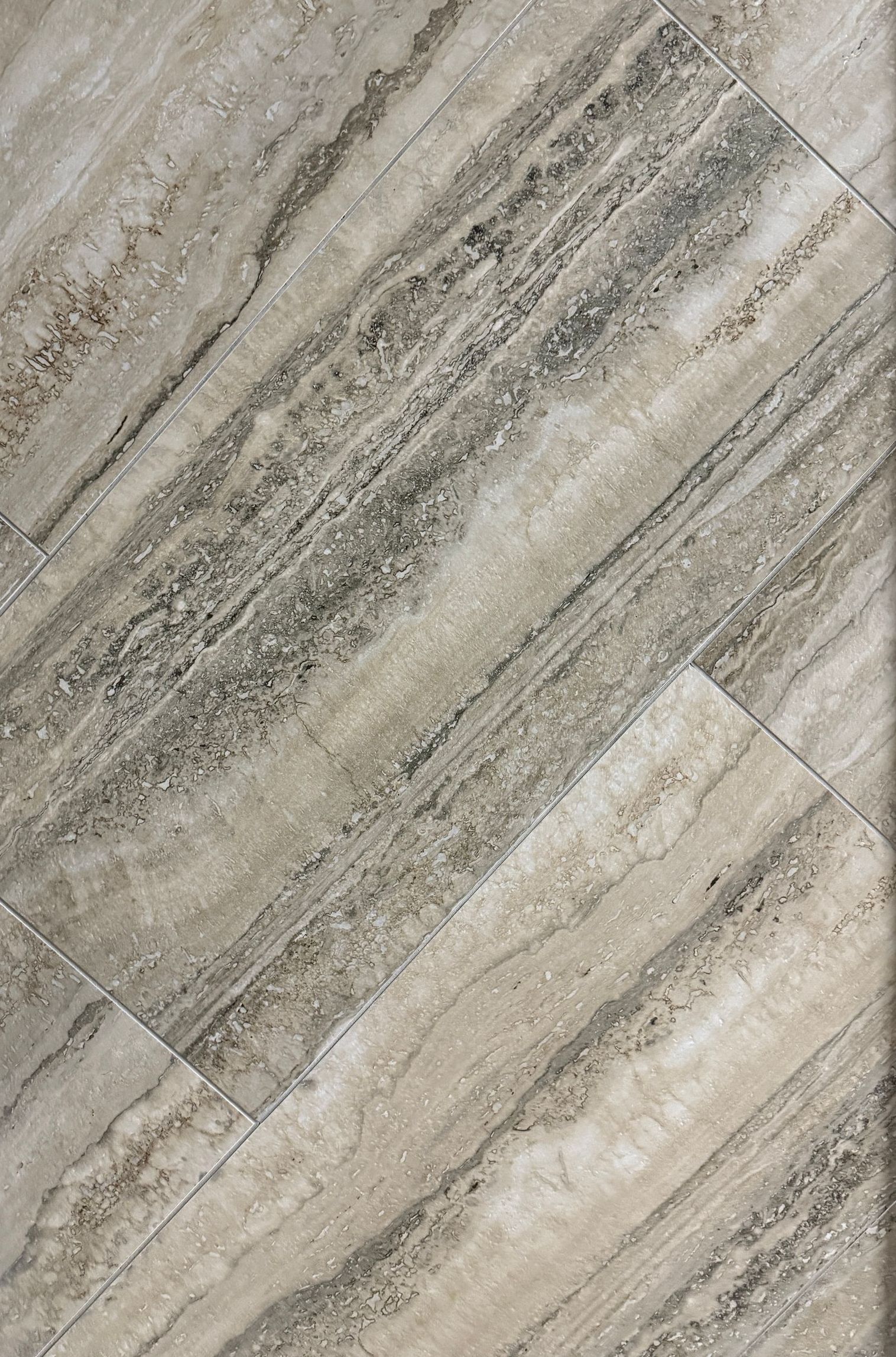 A close up of a tile floor that looks like wood.