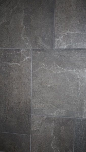 A close up of a gray tile floor with a marble texture.