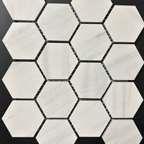 A close up of a white hexagon mosaic tile on a black background.