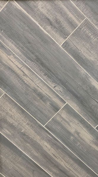 A close up of a gray tile floor that looks like wood.