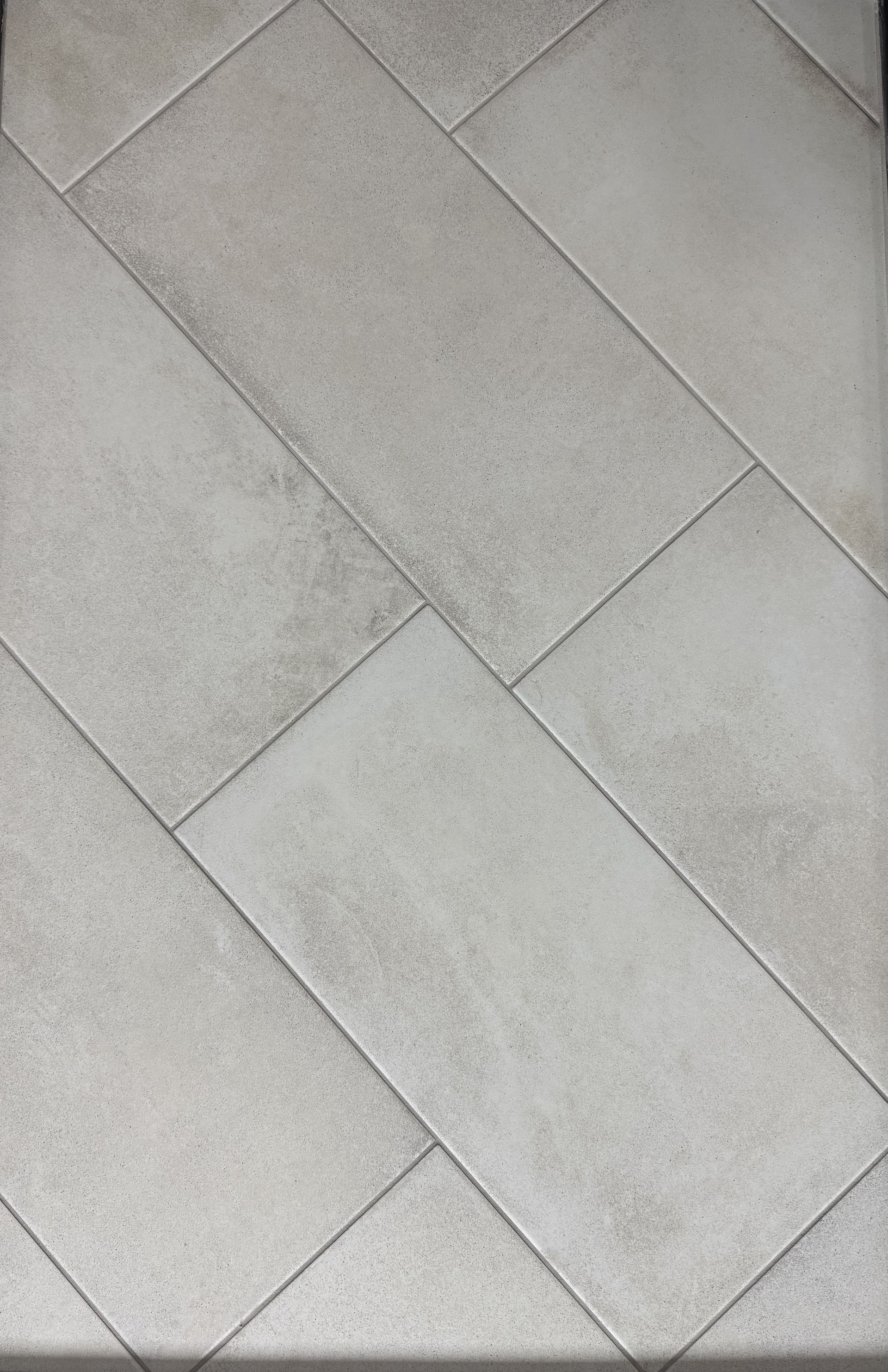 A close up of a brown tile floor with white grout.