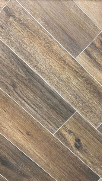 A close up of a tile floor that looks like wood.