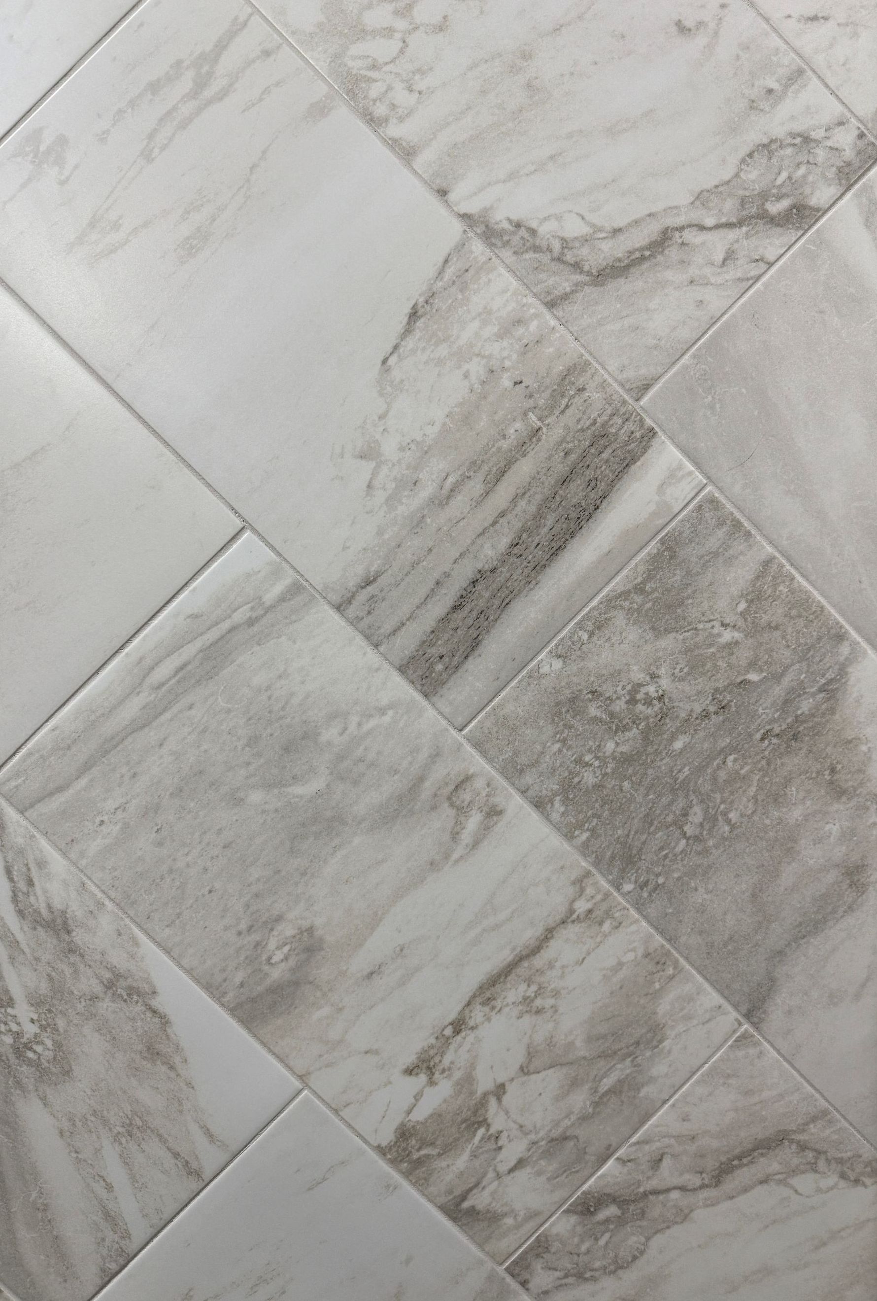 A close up of a white marble tile floor.