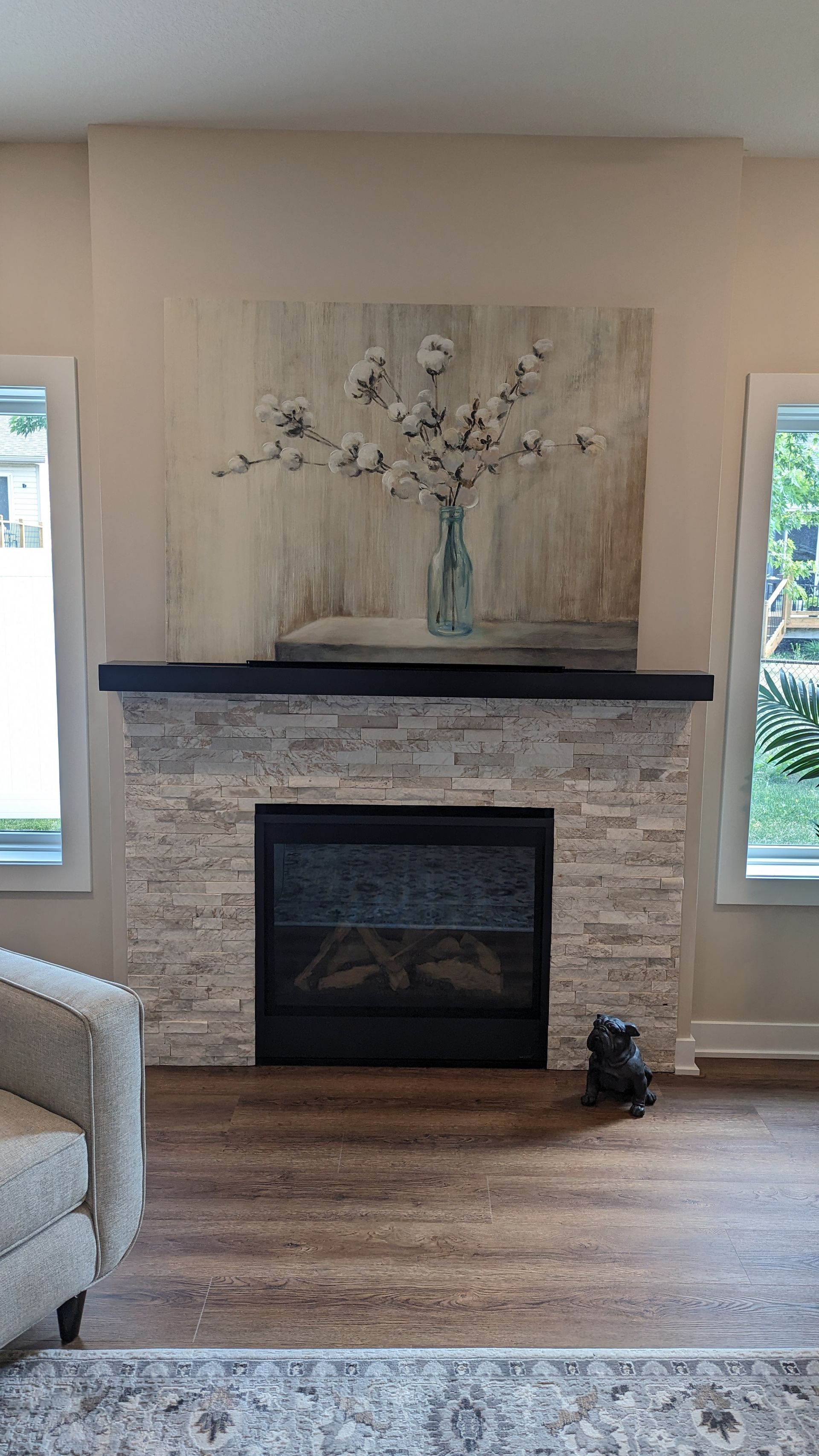 A living room with a fireplace and a painting on the wall.