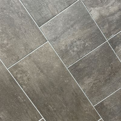 A close up of a gray tile floor with white grout.