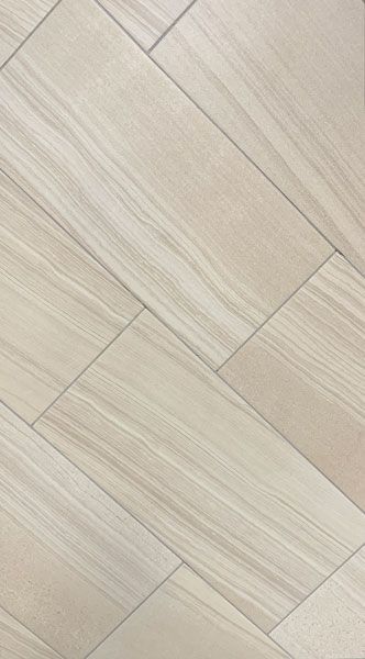 A close up of a white tile floor that looks like wood.