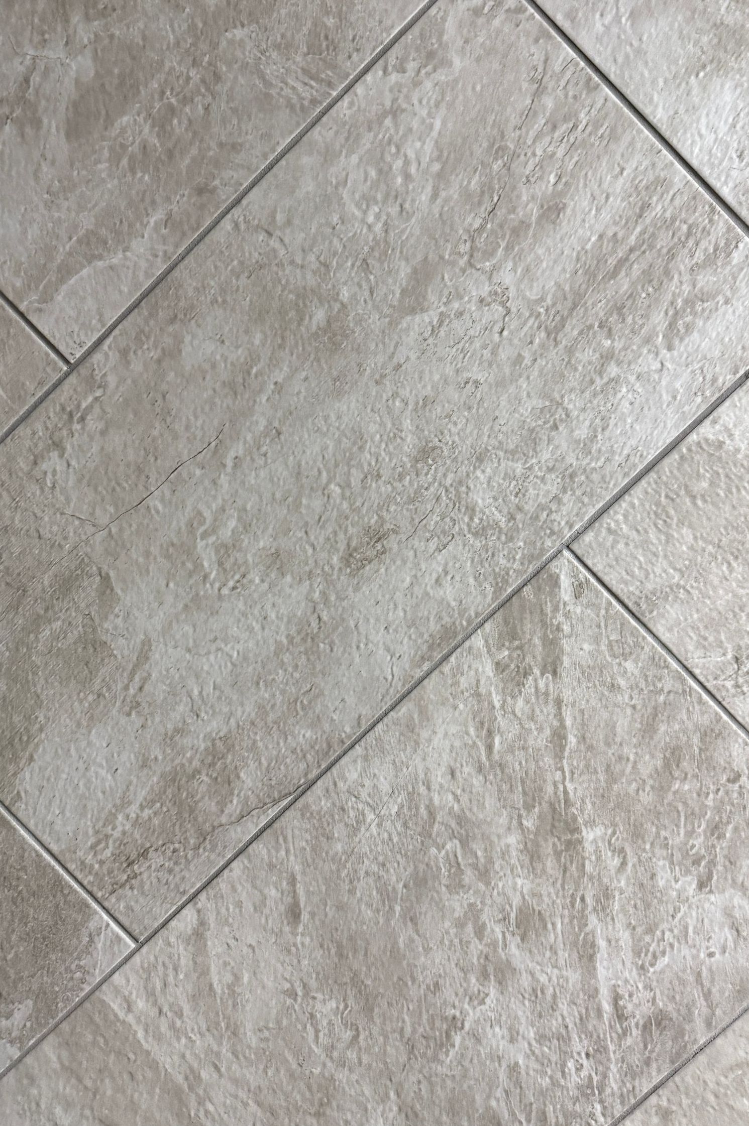 A close up of a tile floor with a diagonal pattern.