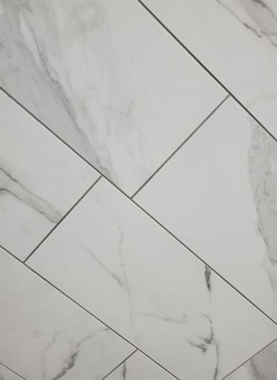 A close up of a white marble tile floor.