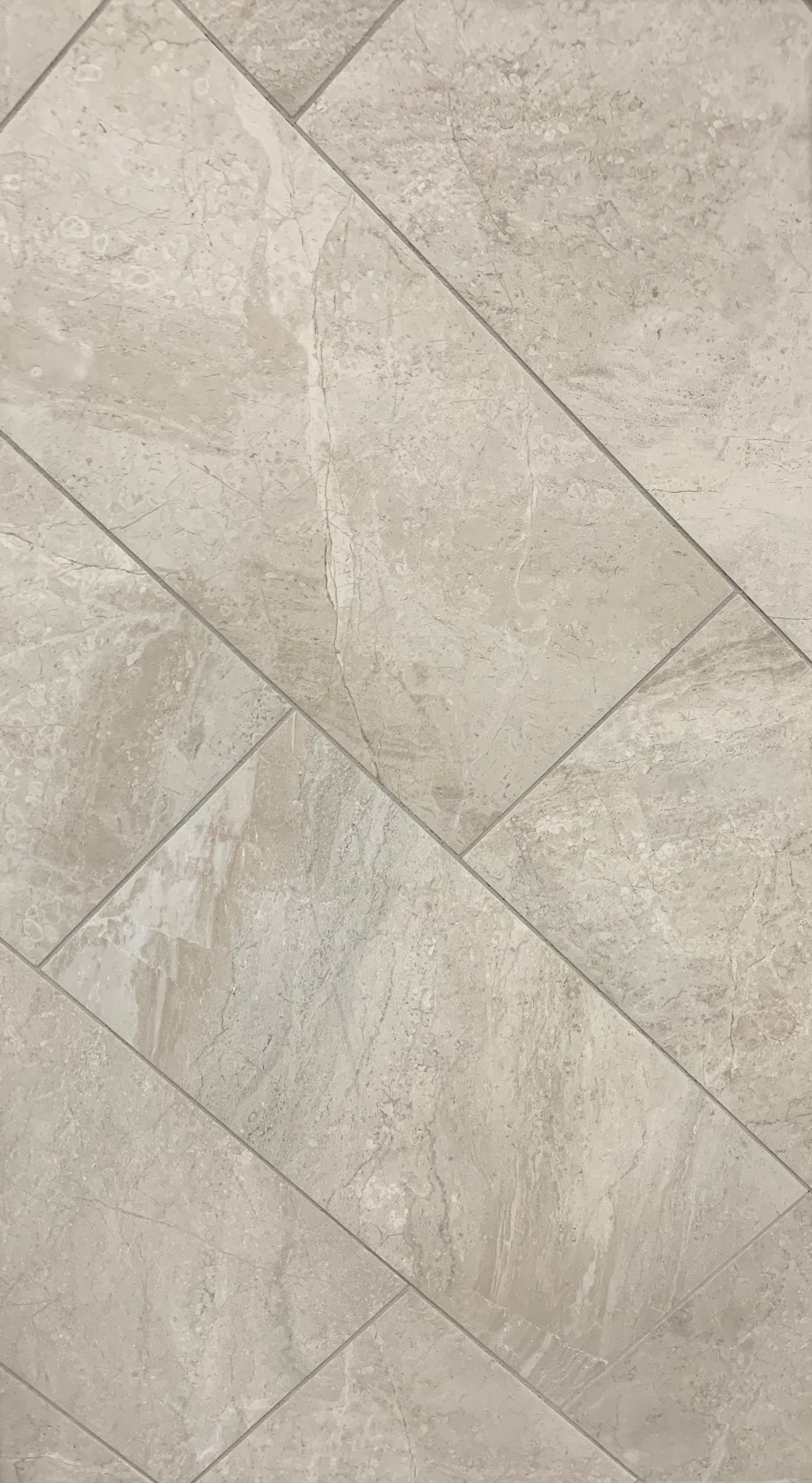 A close up of a white tile floor with a diagonal pattern.