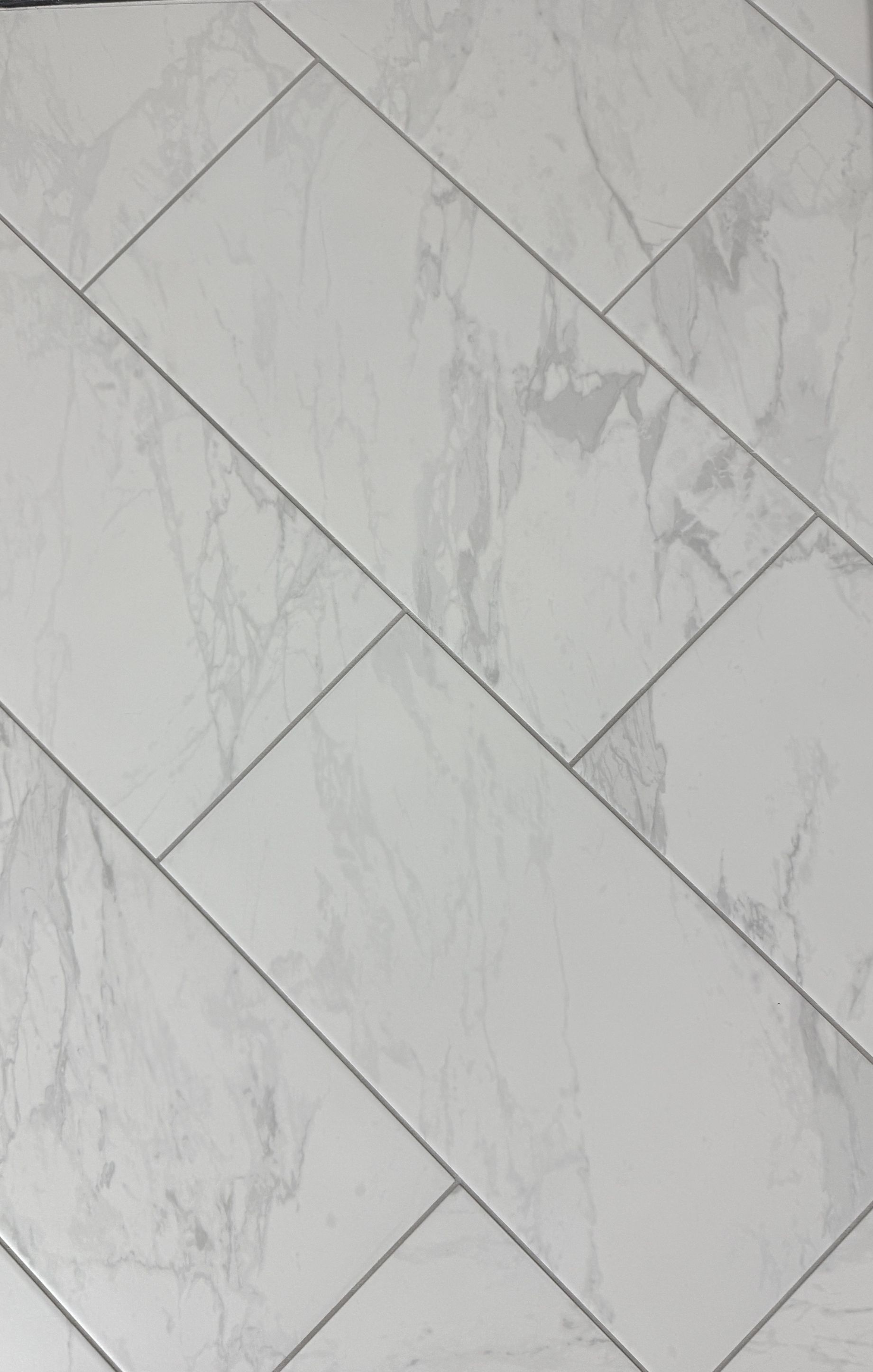 A close up of a white tile floor that looks like wood.