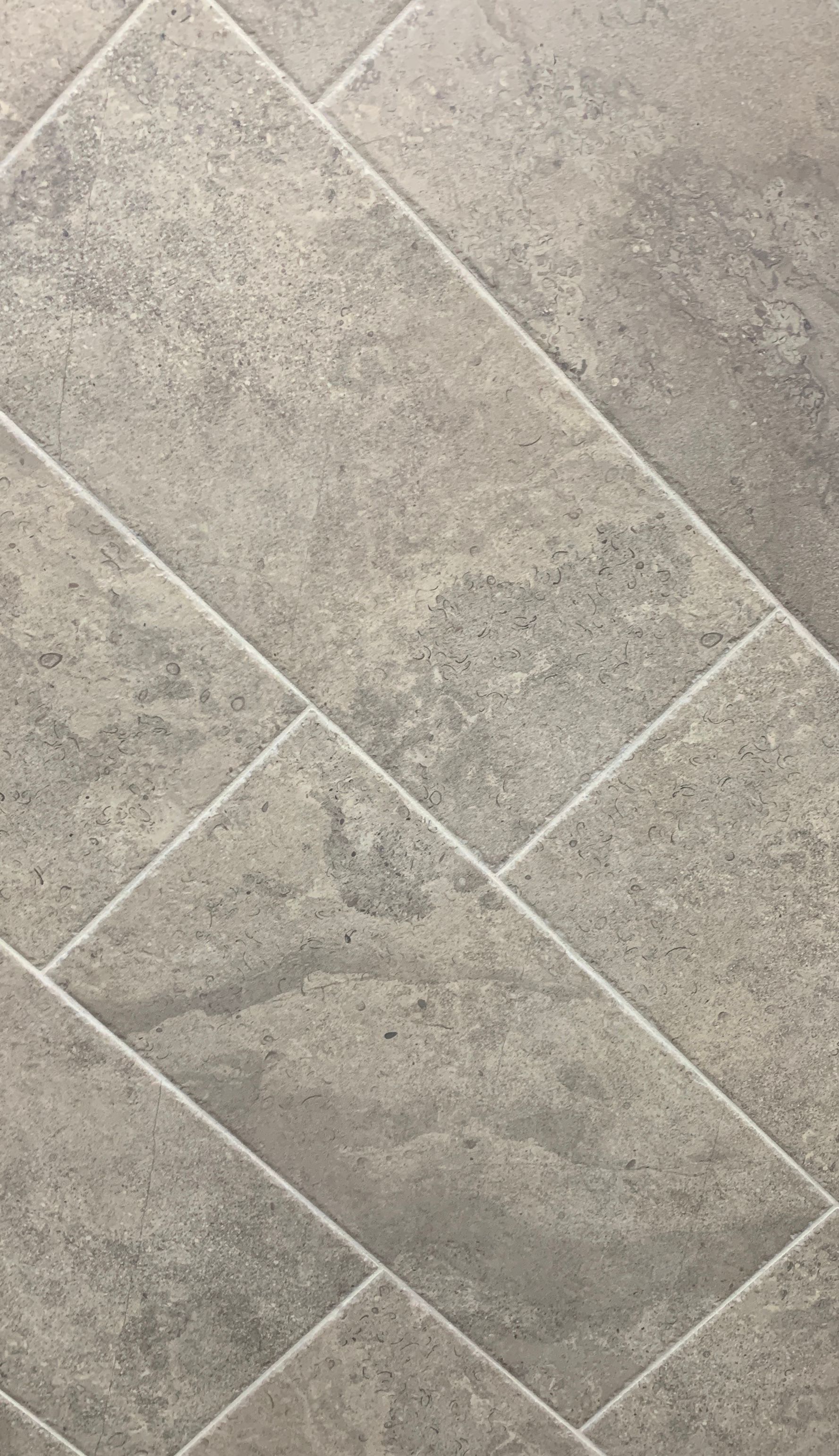 A close up of a tile floor with a diagonal pattern.