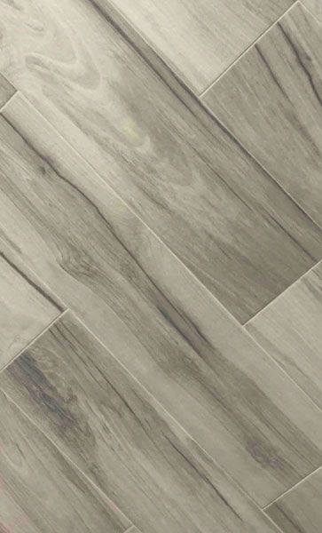 A close up of a gray tile floor that looks like wood.