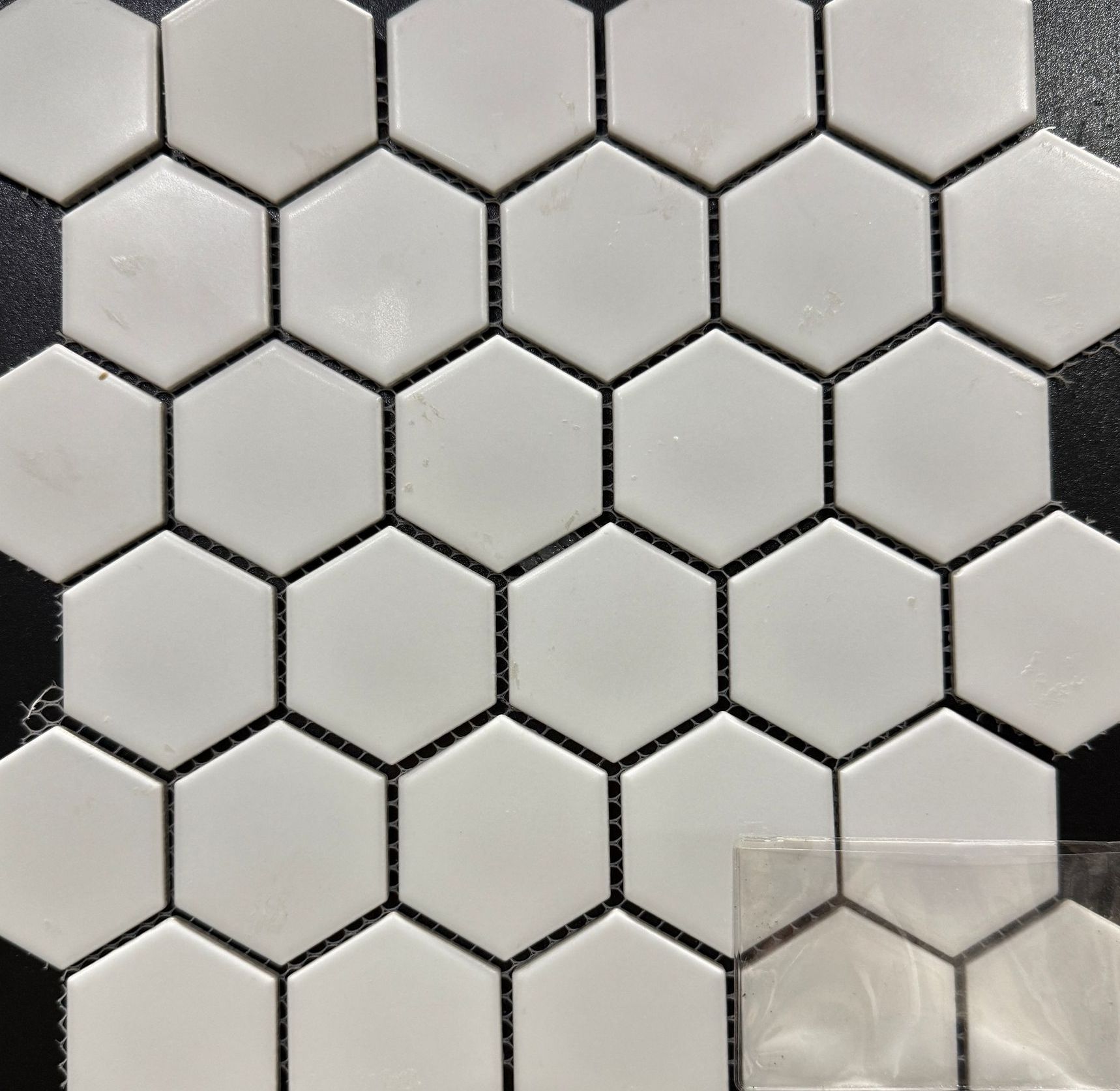 A close up of white hexagon tiles on a black background