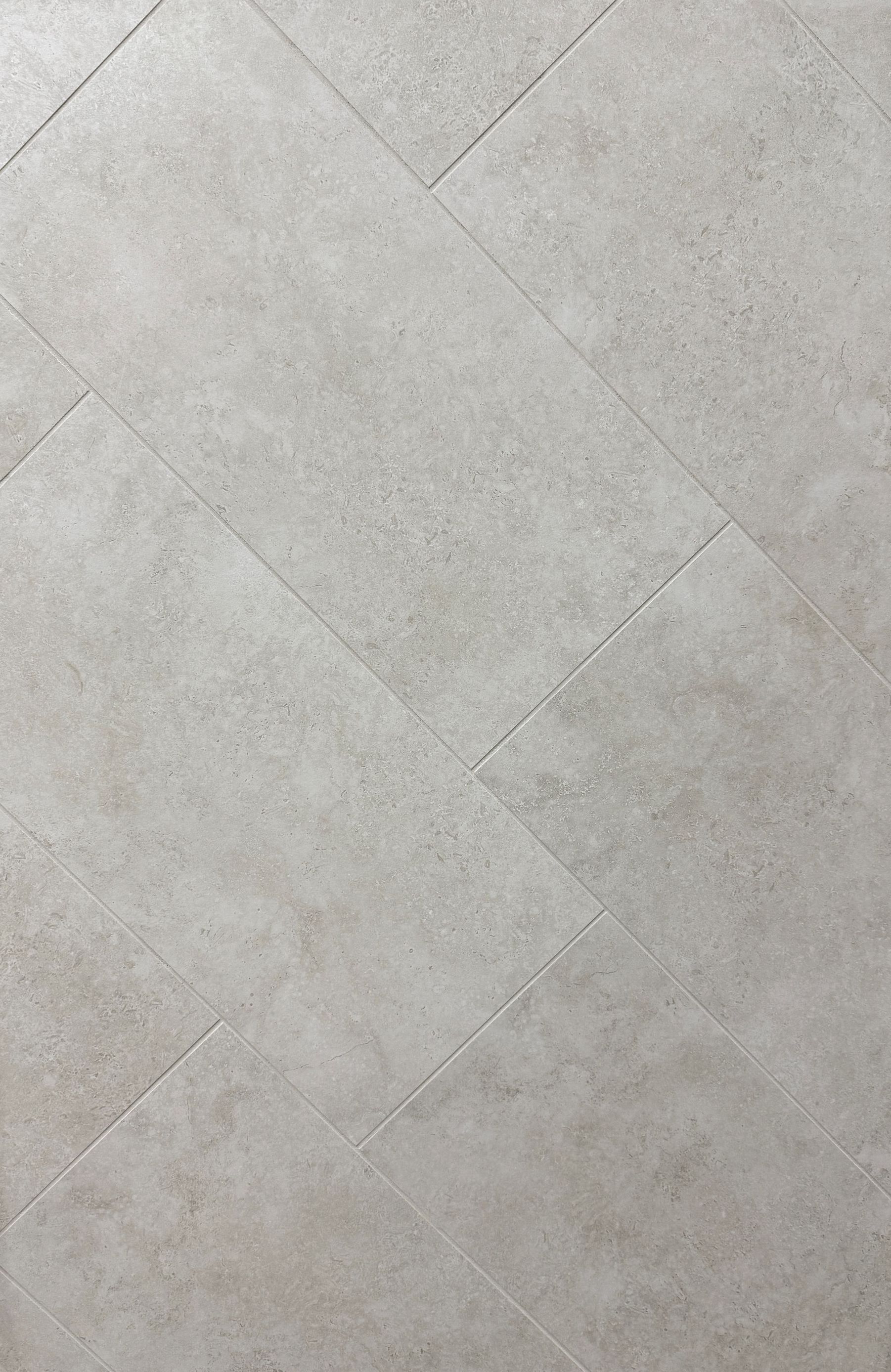 A close up of a tile floor with a diagonal pattern.